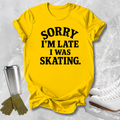 A bright yellow graphic t-shirt with the text 'SORRY I'M LATE I WAS SKATING.' printed in black.
