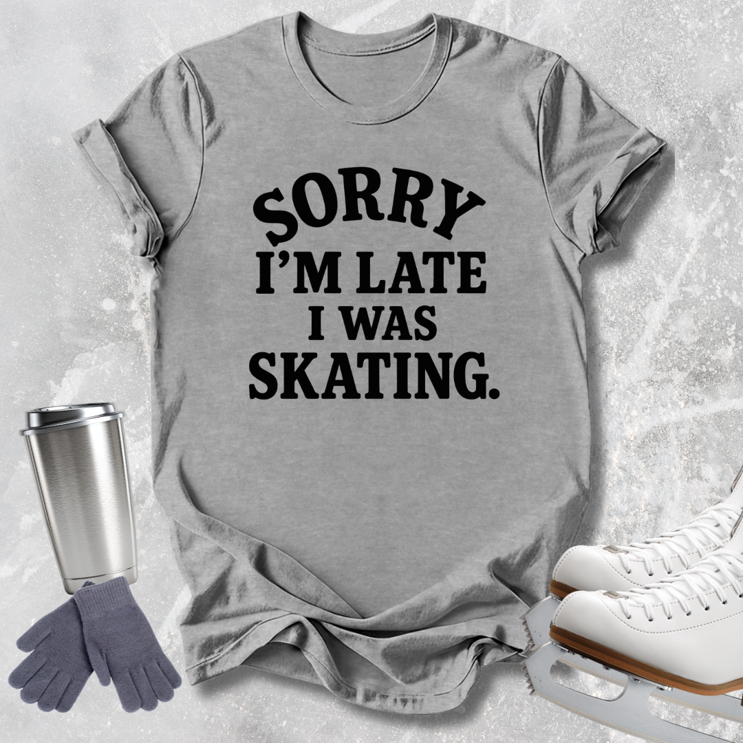 A heather gray short-sleeve t-shirt with the text 'SORRY I'M LATE I WAS SKATING.' printed in black across the front.