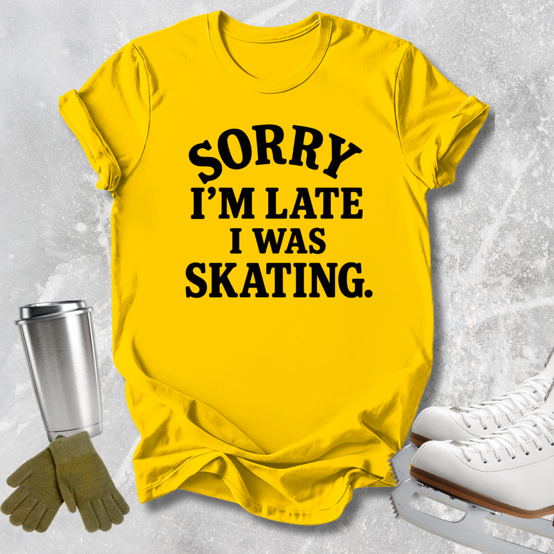 A bright yellow graphic t-shirt with the text 'SORRY I'M LATE I WAS SKATING.' printed in black.