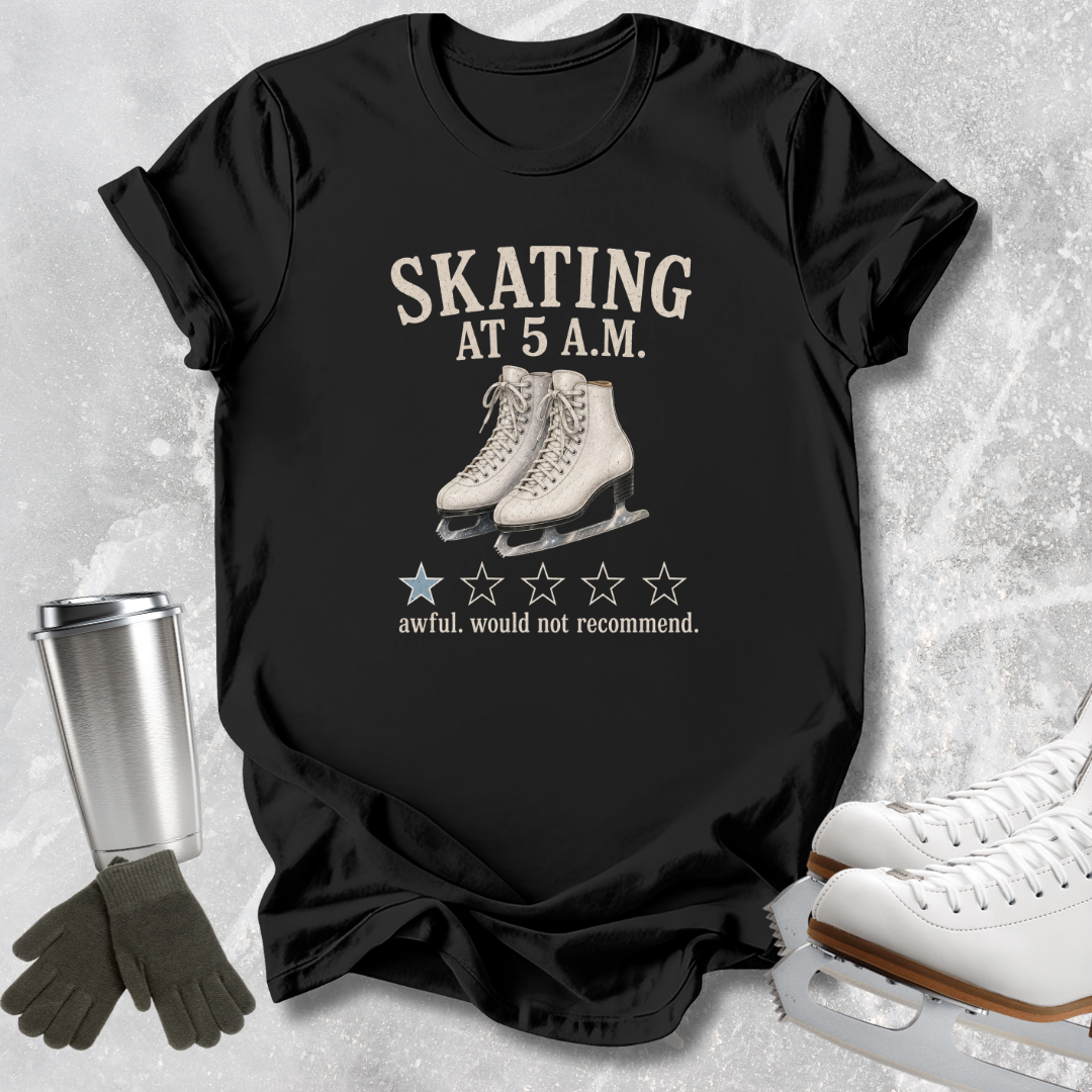 A black graphic t-shirt laid flat on a light gray textured background, featuring the text 'SKATING AT 5 A.M.
