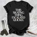 A black graphic t-shirt laid flat on a light gray textured background, featuring the text 'SKATING AT 5 A.M.