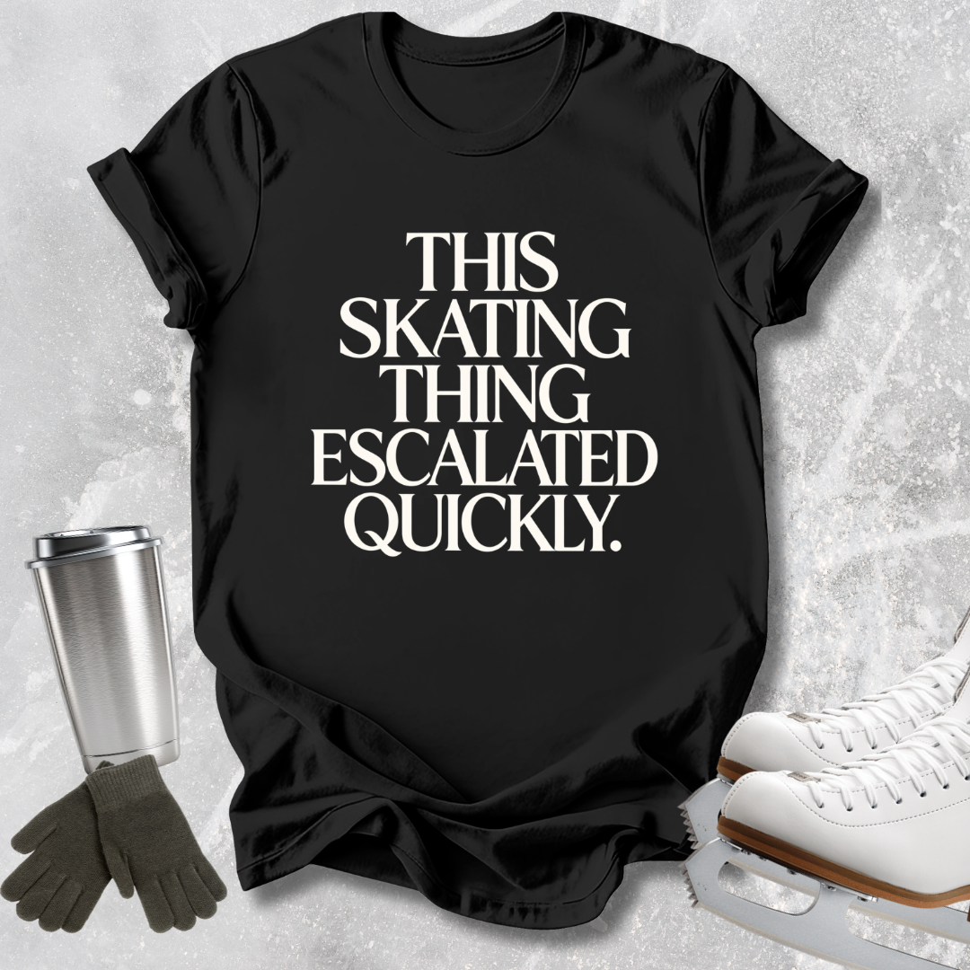 A black graphic t-shirt laid flat on a light gray textured background, featuring the text 'SKATING AT 5 A.M.