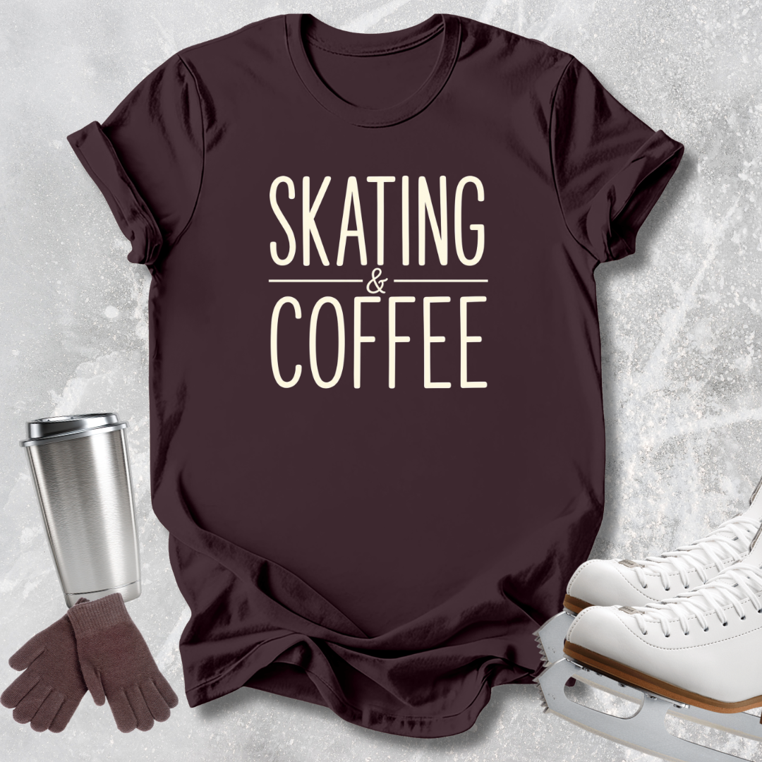 A dark brown short-sleeve t-shirt with the words 'SKATING & COFFEE' printed in cream on the front, styled in a flat lay with white ice skates, a stainless steel travel mug, and a pair of brown gloves on a light gray textured background.