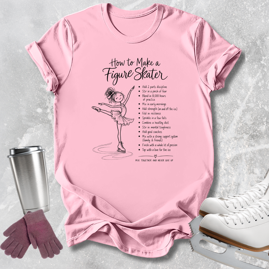 A pink graphic T-shirt laid flat on a light gray textured surface, featuring a black illustration of a figure skater and the text 'How to Make a Figure Skater' with a list of tips. White ice skates, a metal travel mug, and mauve gloves are arranged around the shirt as styling props.